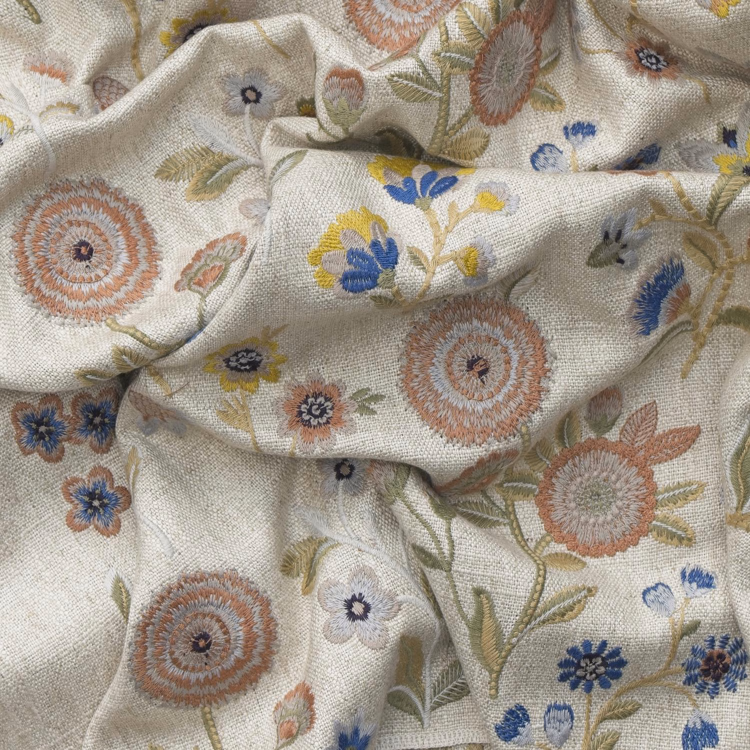 Ivory linen-look cloth with terracotta rosettes and blue botanical embroidery
