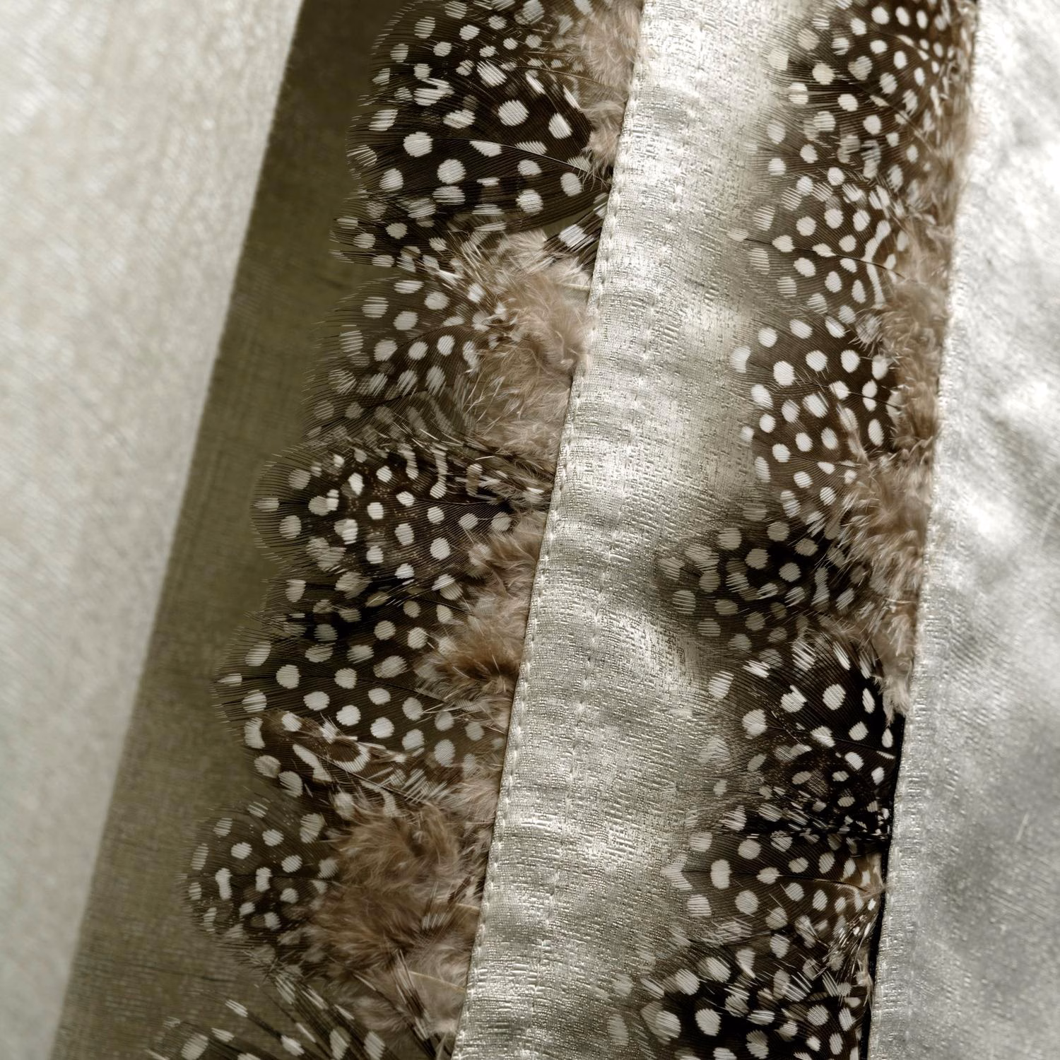 Olive and silver fabric with spotted guinea feathers and a softly textured sheen