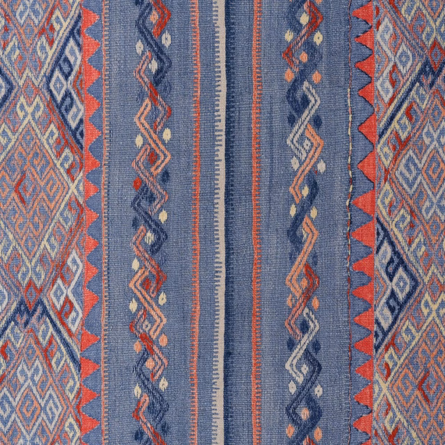 Close view of denim-blue woven stripes with coral, cream and navy diamond motifs
