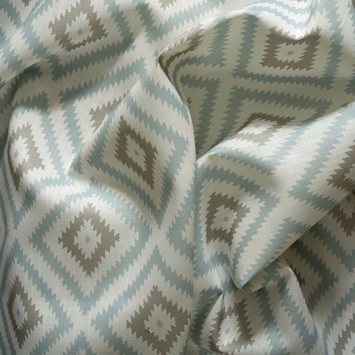 Icy blue outdoor fabric with sage-grey zigzag diamonds and softly textured folds