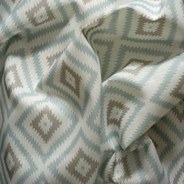 Icy blue outdoor fabric with sage-grey zigzag diamonds and softly textured folds