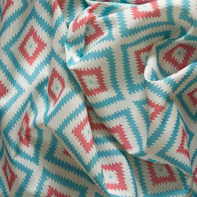 Aqua teal outdoor fabric with coral diamonds and cream zigzag borders