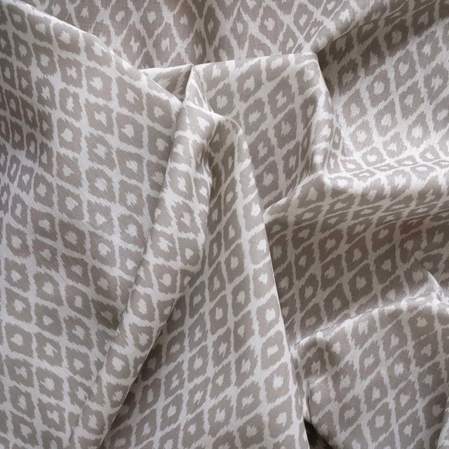 Cool taupe-grey outdoor fabric with ivory geometric motifs draped in soft folds