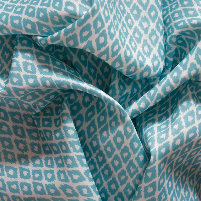 Turquoise teal fabric with cream ikat diamonds gathered into softly lustrous folds