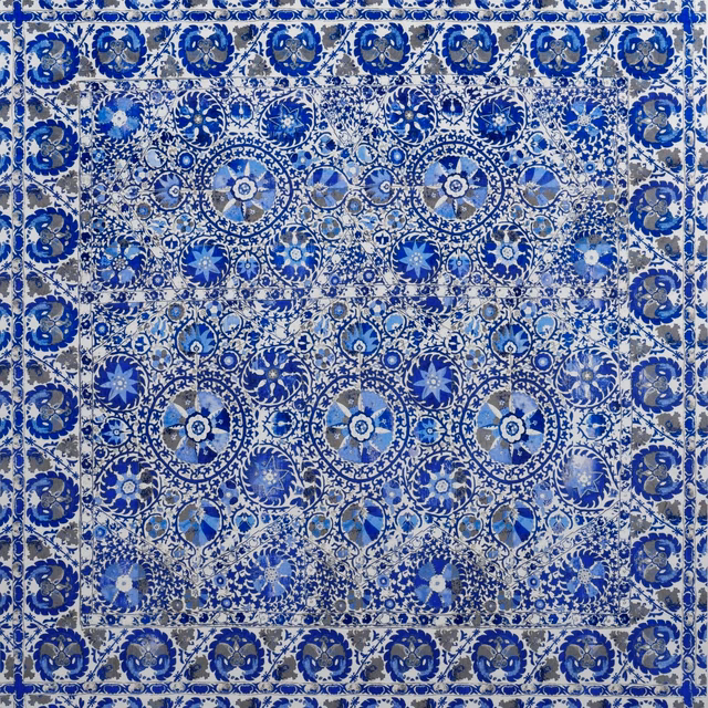 Cobalt blue textile with white floral medallions and a dense ornamental border