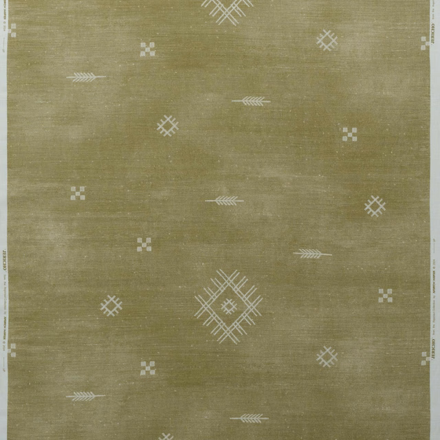 Muted olive woven fabric with scattered ivory diamonds, crosses and arrow motifs