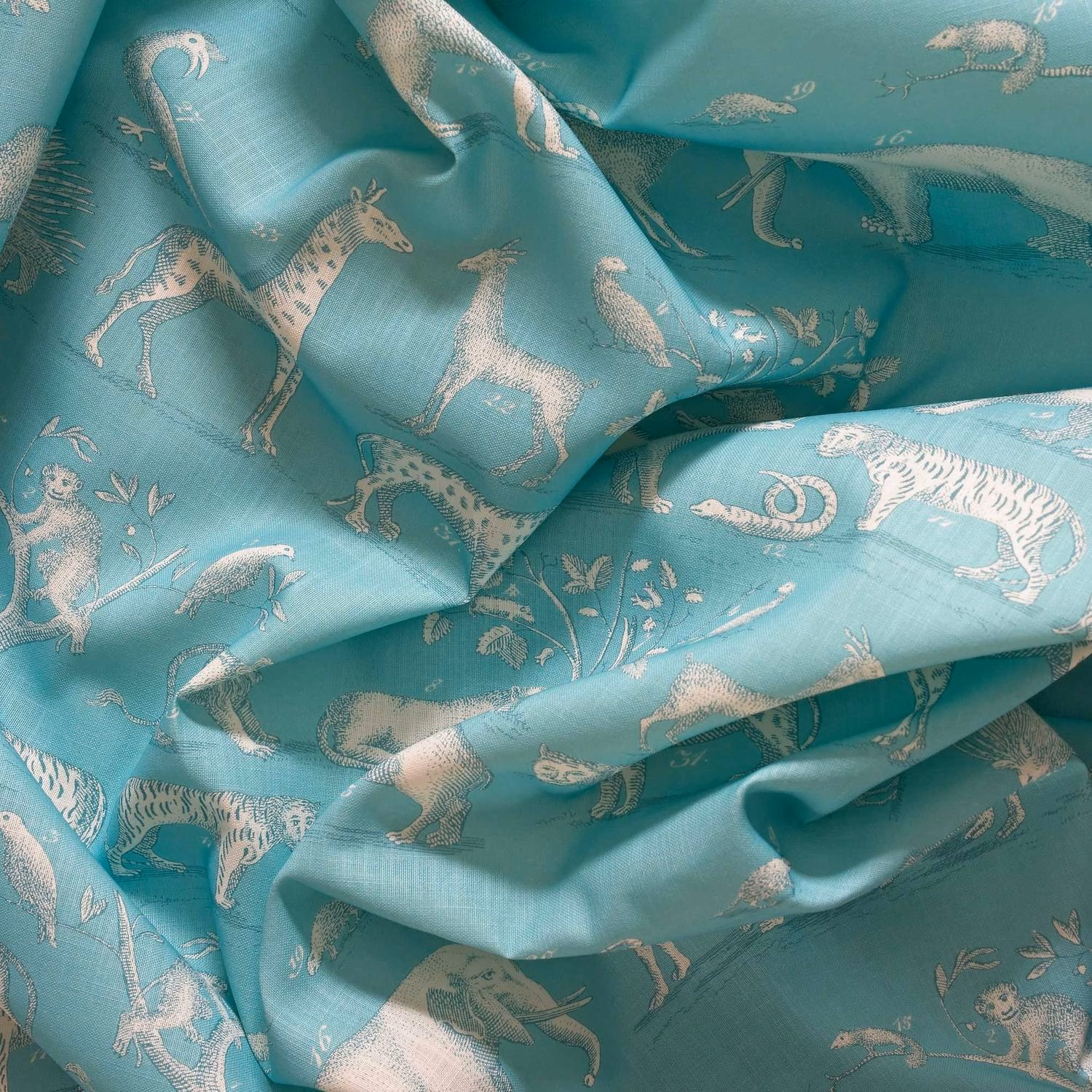Lagoon teal fabric with pale safari animals and a softly lustrous woven surface