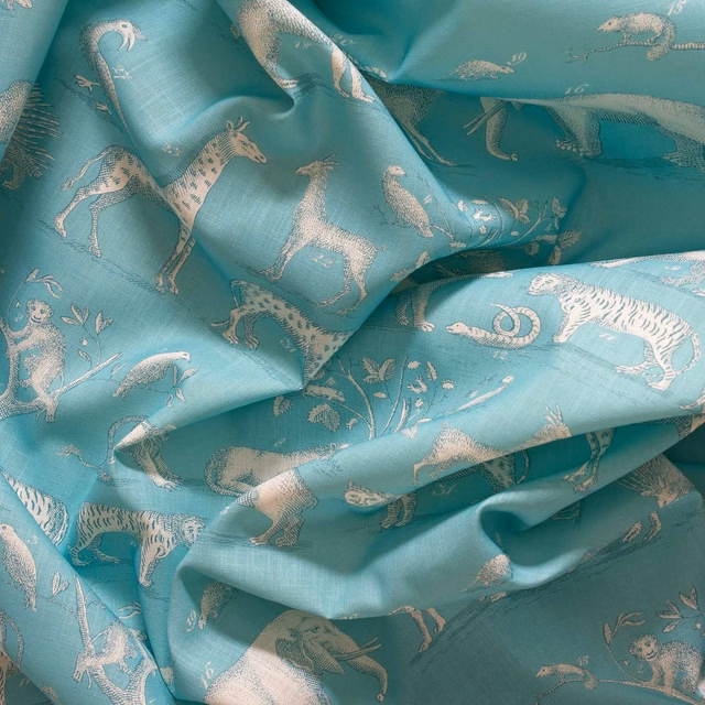 Lagoon teal fabric with pale safari animals and a softly lustrous woven surface