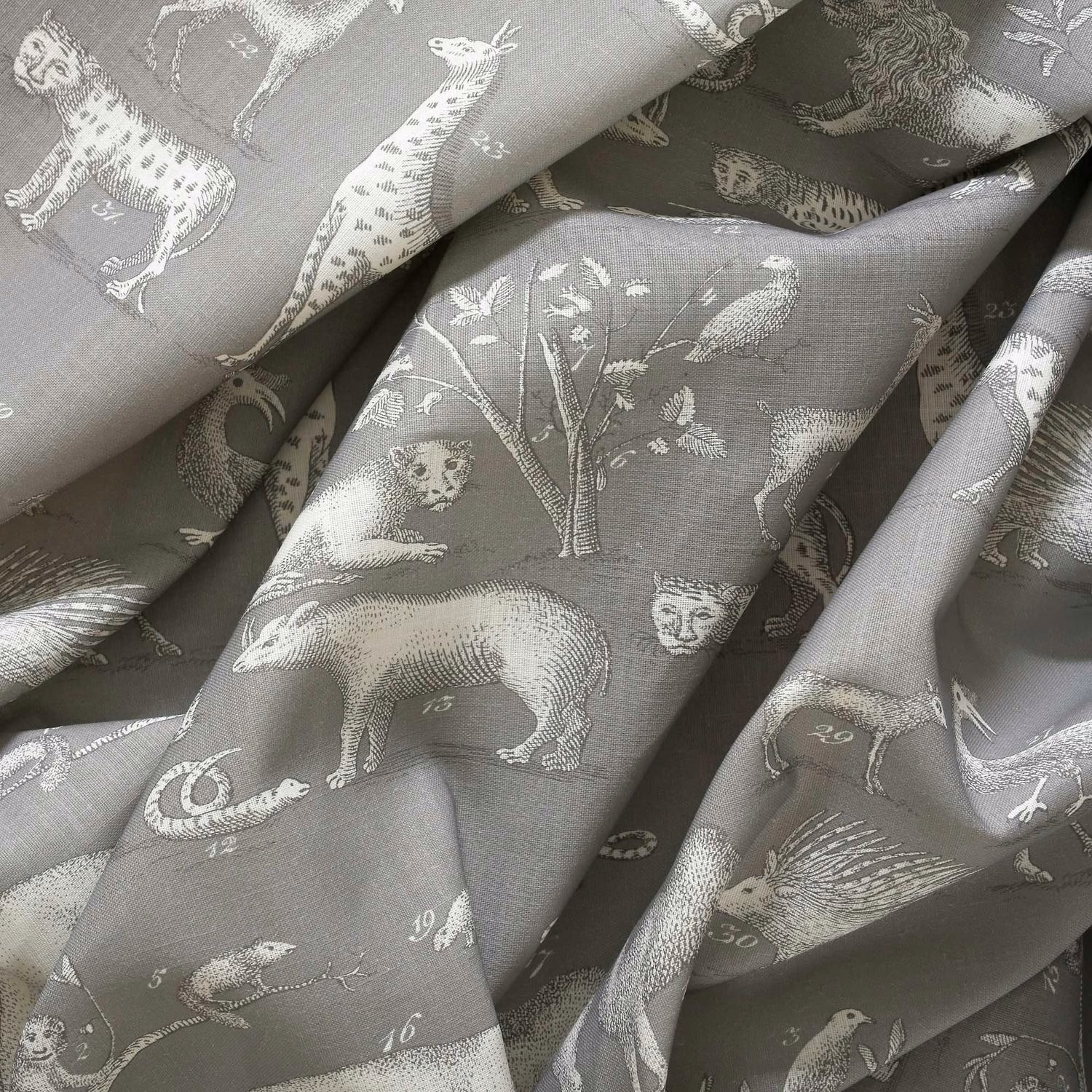 Stone-grey woven fabric with ivory animals, birds, foliage and numbered illustrations