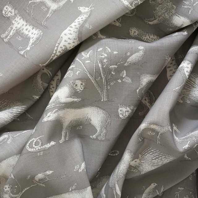 Stone-grey woven fabric with ivory animals, birds, foliage and numbered illustrations