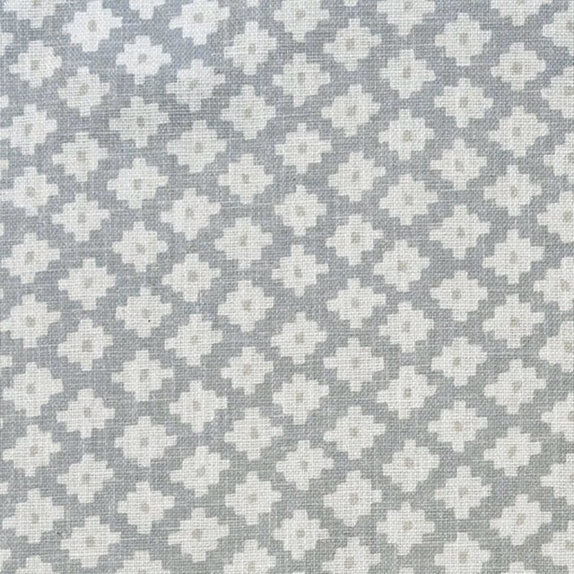 Cool grey woven ground with repeated ivory pixel-like geometric motifs