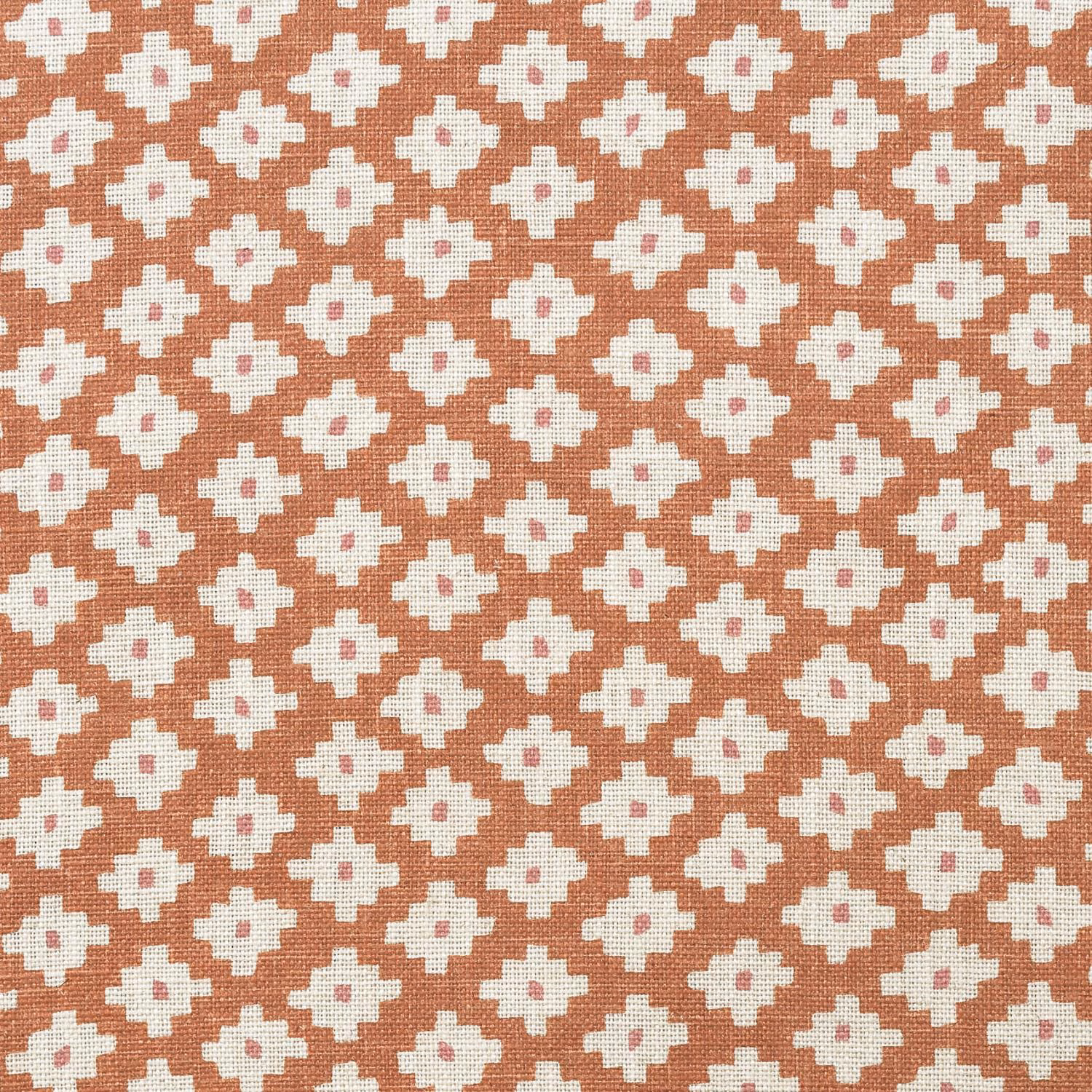 Muted terracotta orange woven fabric with repeated cream cross motifs