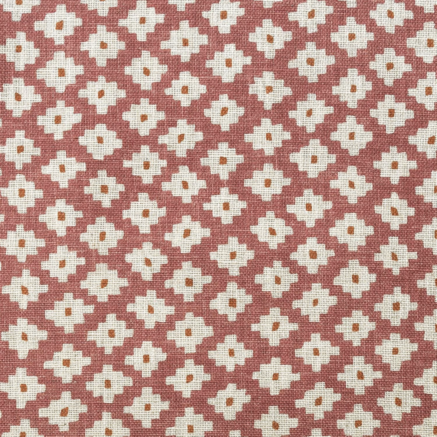 Dusty rose woven fabric with repeating ivory geometric flower motifs