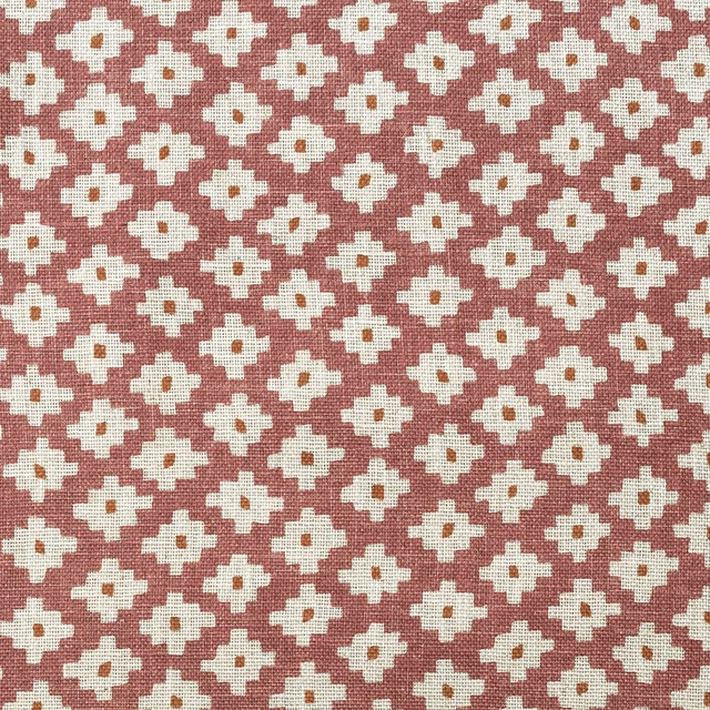 Dusty rose woven fabric with repeating ivory geometric flower motifs