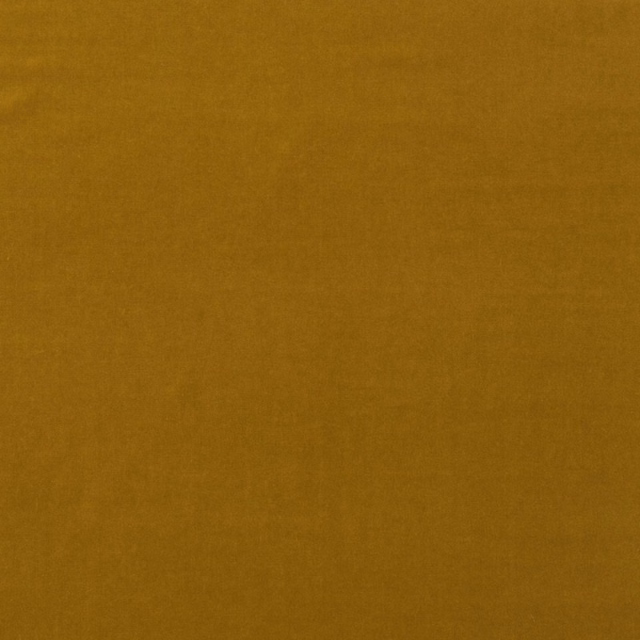 Close-up of plain quince-gold velvet with a softly varied, light-catching nap