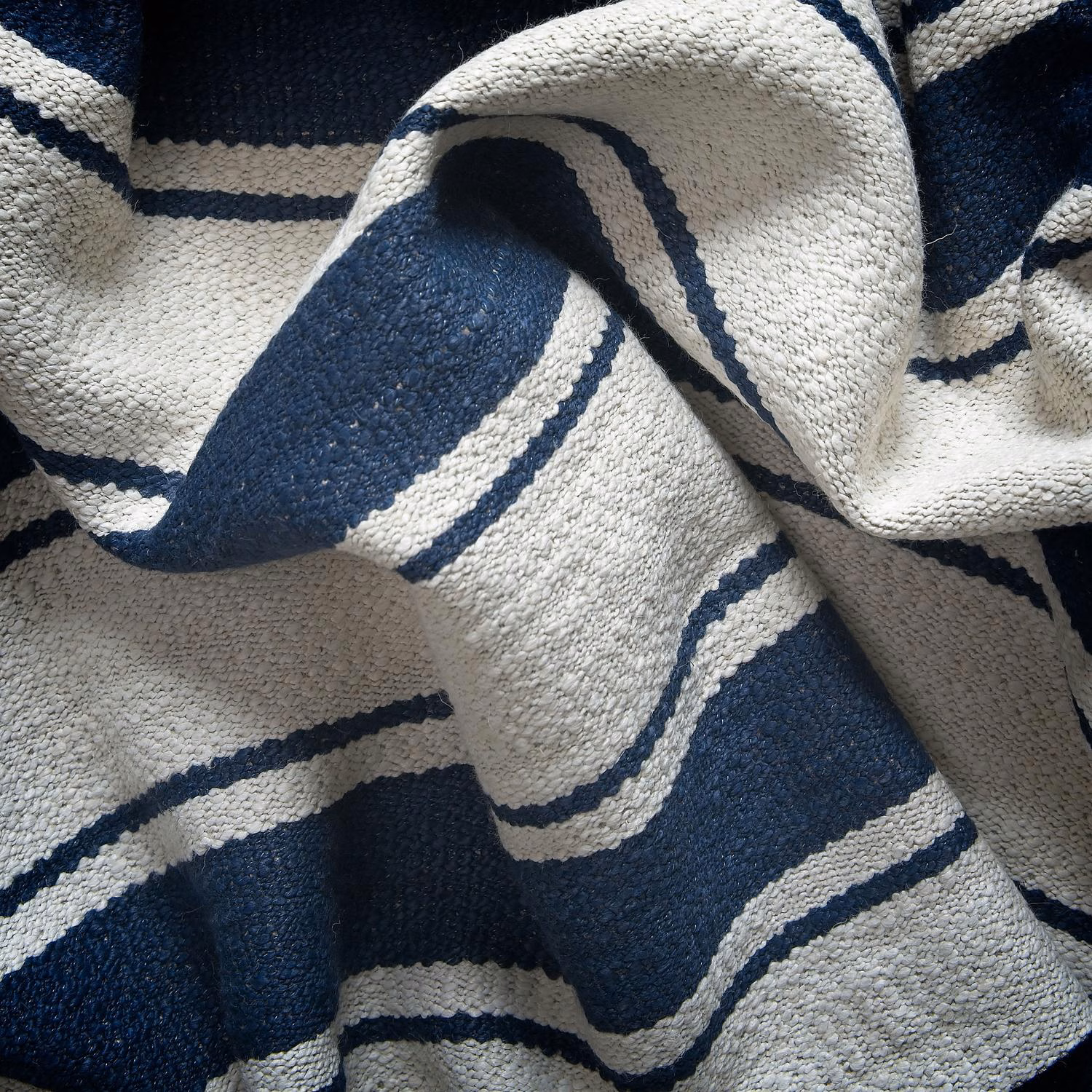 Nubby ivory and deep navy striped fabric gathered into sculptural folds