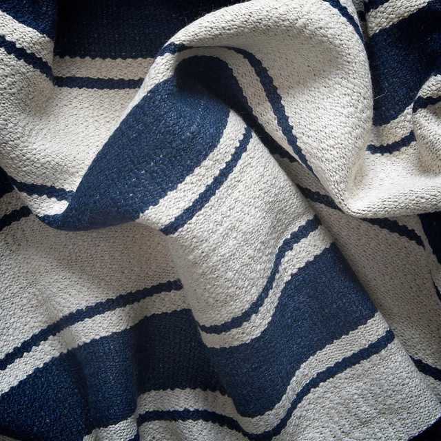 Nubby ivory and deep navy striped fabric gathered into sculptural folds