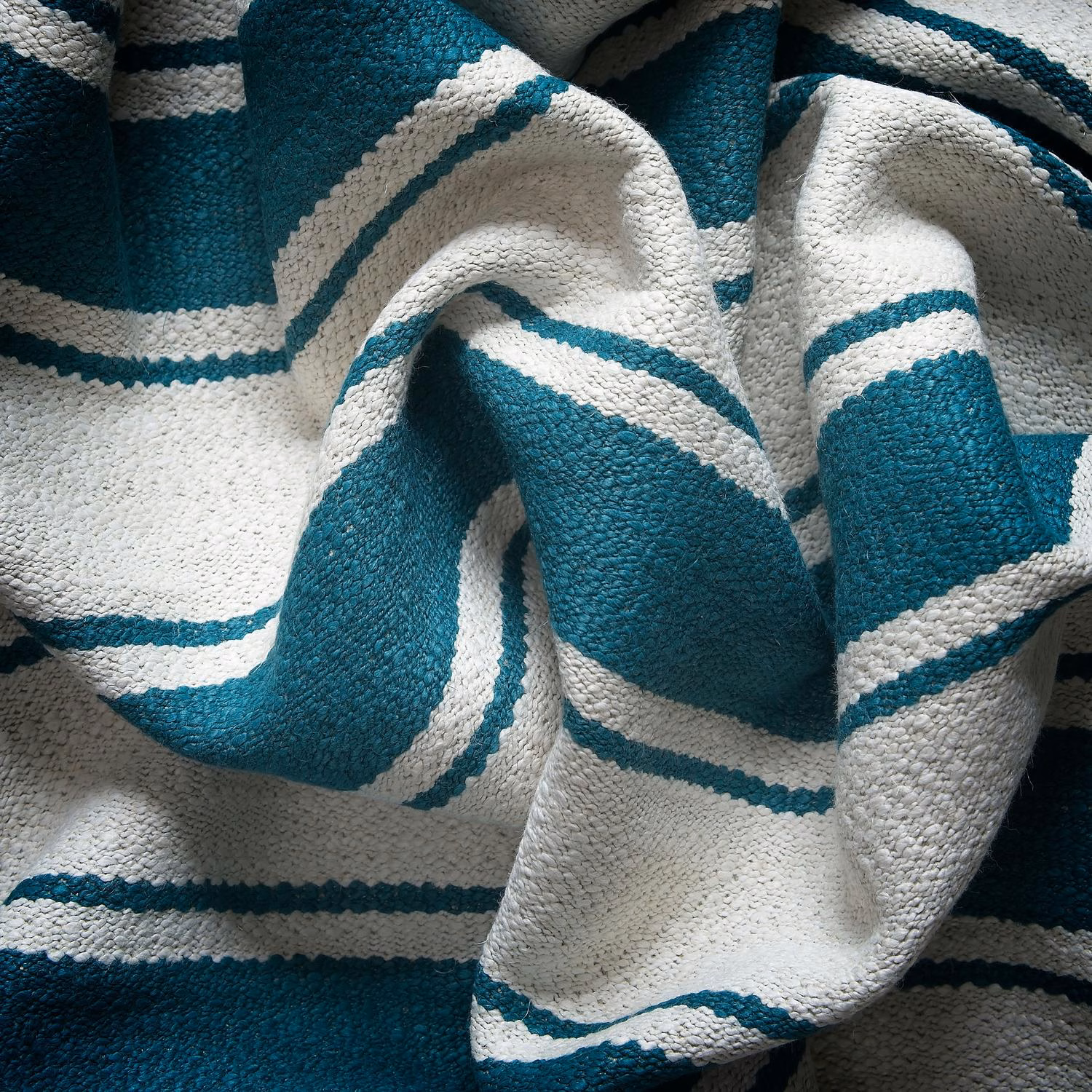 Close-up of deep teal and ivory raised stripes in a chunky woven fabric