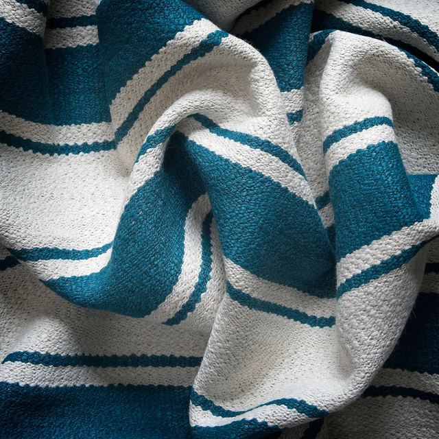 Close-up of deep teal and ivory raised stripes in a chunky woven fabric
