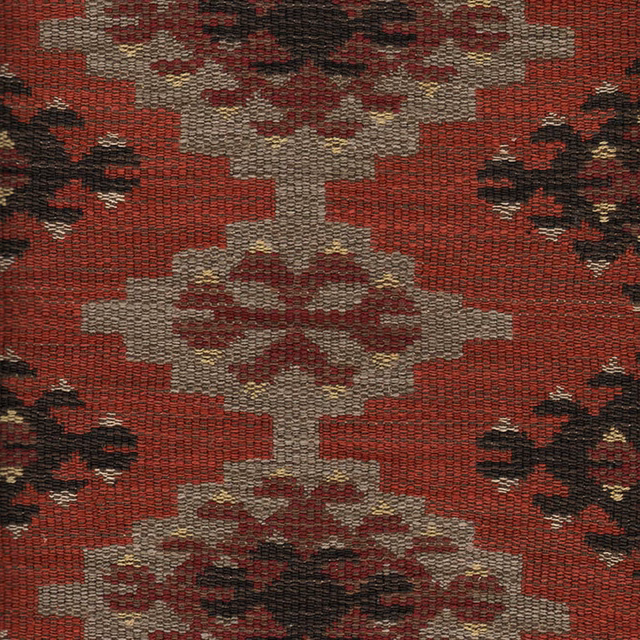Brick-red woven fabric with stepped stone motifs and dark floral accents