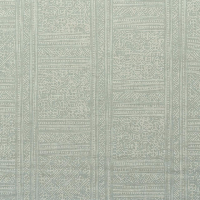 Pale celadon green textile with distressed geometric panels and ornate vertical bands