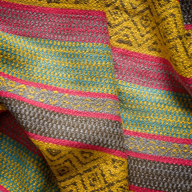Chunky ochre yellow woven fabric with turquoise, pink, grey and taupe geometric bands