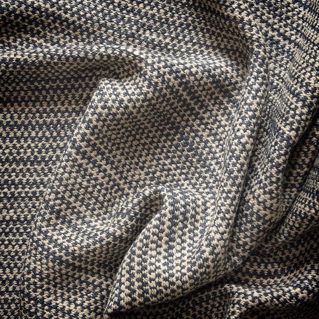 Charcoal and cream woven textile with tiny geometric flecks and sculptural folds