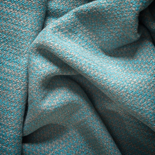 Close-up of nubby glacier-teal weave with grey flecks and sculpted folds