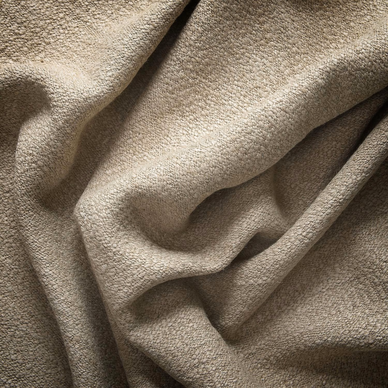 Warm sand-beige fabric with dense pebbled texture gathered into soft folds