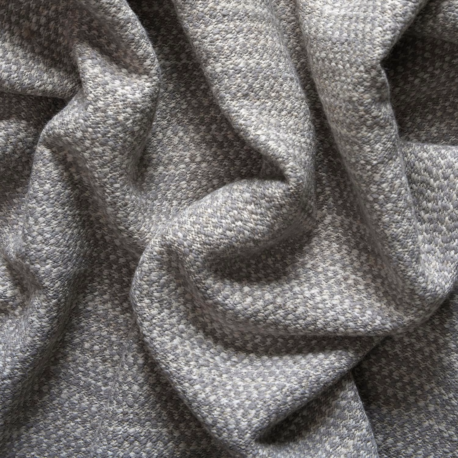 Mottled cool-grey woven fabric folded into deep, softly textured sculptural pleats