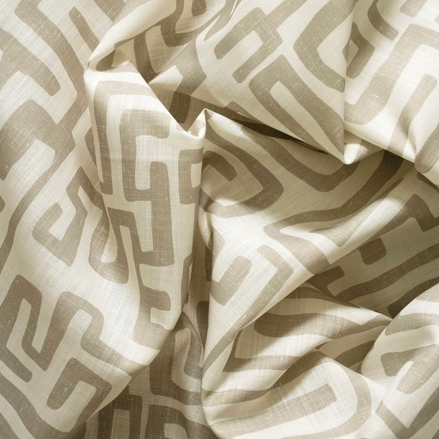 Cream woven fabric with taupe irregular geometric lines gathered into soft folds
