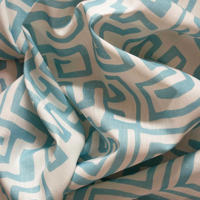 Muted lagoon teal abstract marks on ivory textured outdoor fabric in soft folds