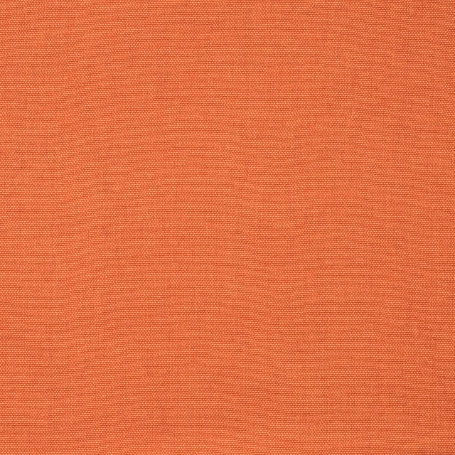 Close-up of warm terracotta orange fabric with a fine, even woven texture