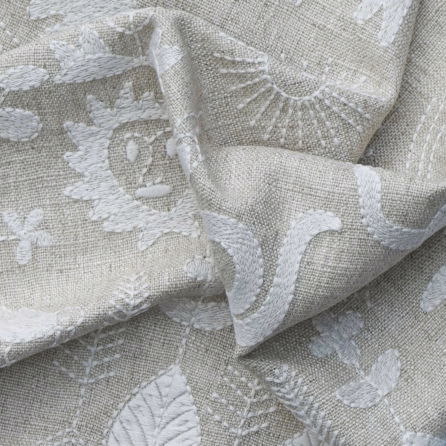 Warm ivory greige fabric with raised chalky botanical motifs and a tactile woven texture