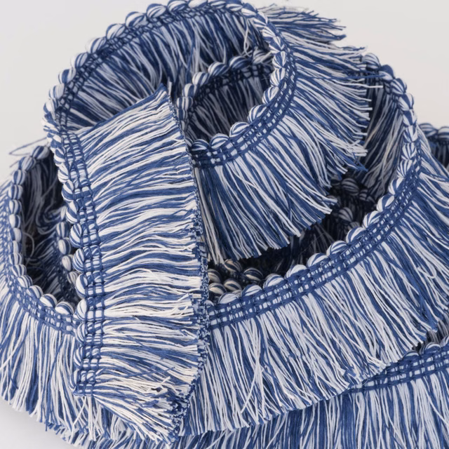 Close-up of layered navy and white fringed trim with looped woven edges