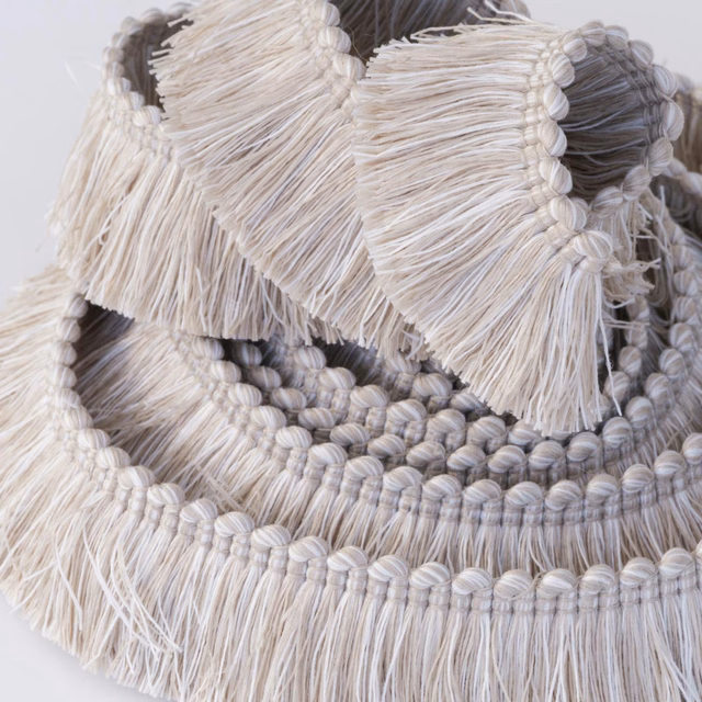 Pale sand and grey looped fringe trim with layered tassel texture