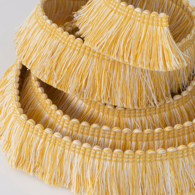 Warm golden-yellow outdoor trim with cream fringe and rounded braided rows