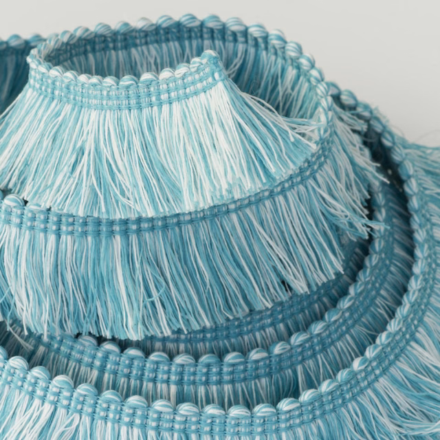 Cool turquoise trim with pale fringe and rounded braided bands in layered coils
