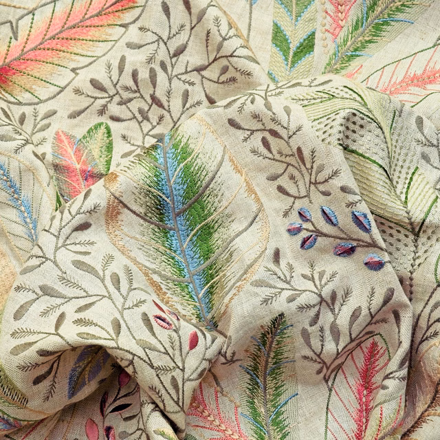 Pale ivory botanical textile with pink, green and blue embroidered feather motifs