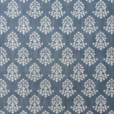 Muted denim-blue textile with ivory sprig motifs and a softly slubbed weave