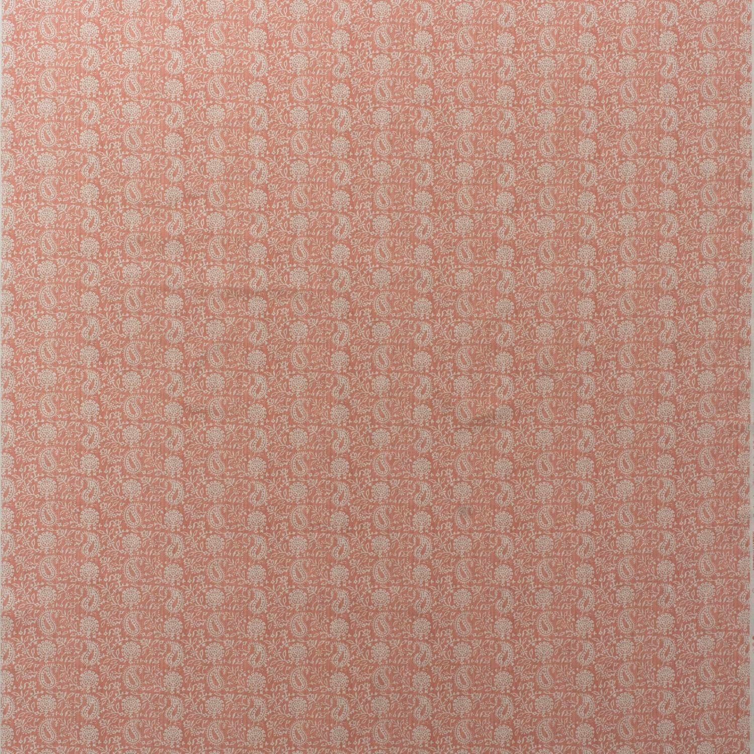 Warm coral-pink cotton print with dense cream paisley motifs in a fine repeat