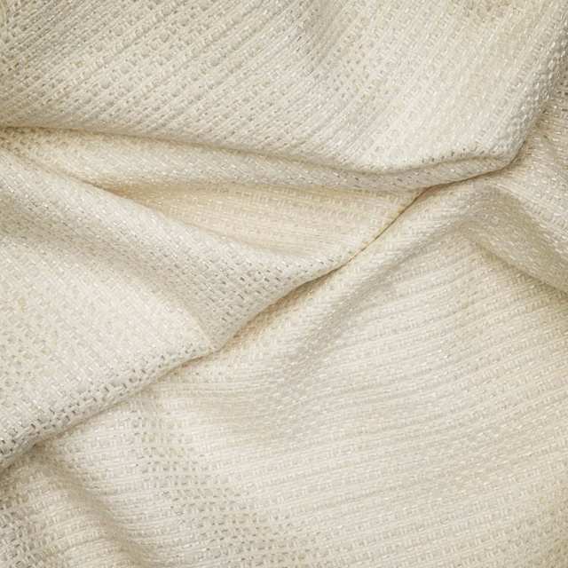 Warm chalk off-white fabric showing a fine, softly ridged woven texture in folded layers