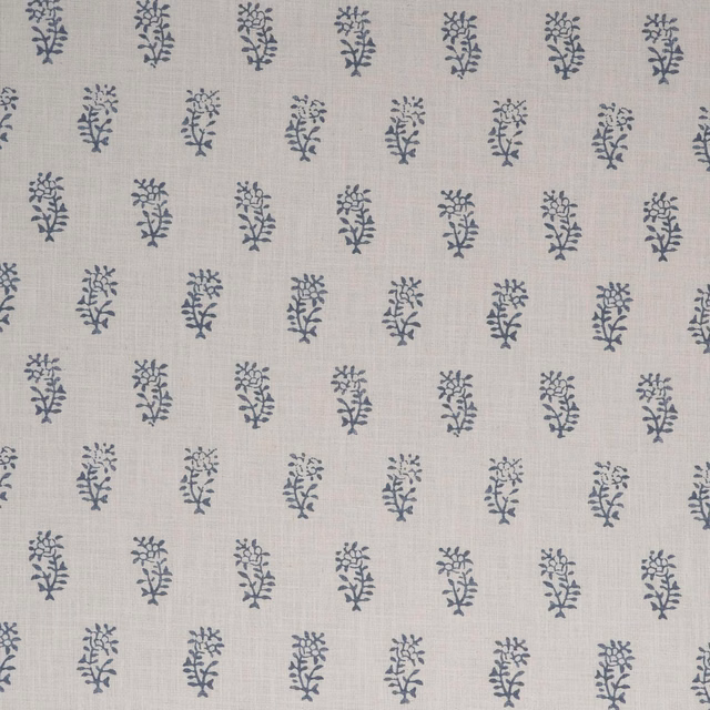 Pale linen-grey fabric with repeated blue-grey botanical sprigs and fine woven texture