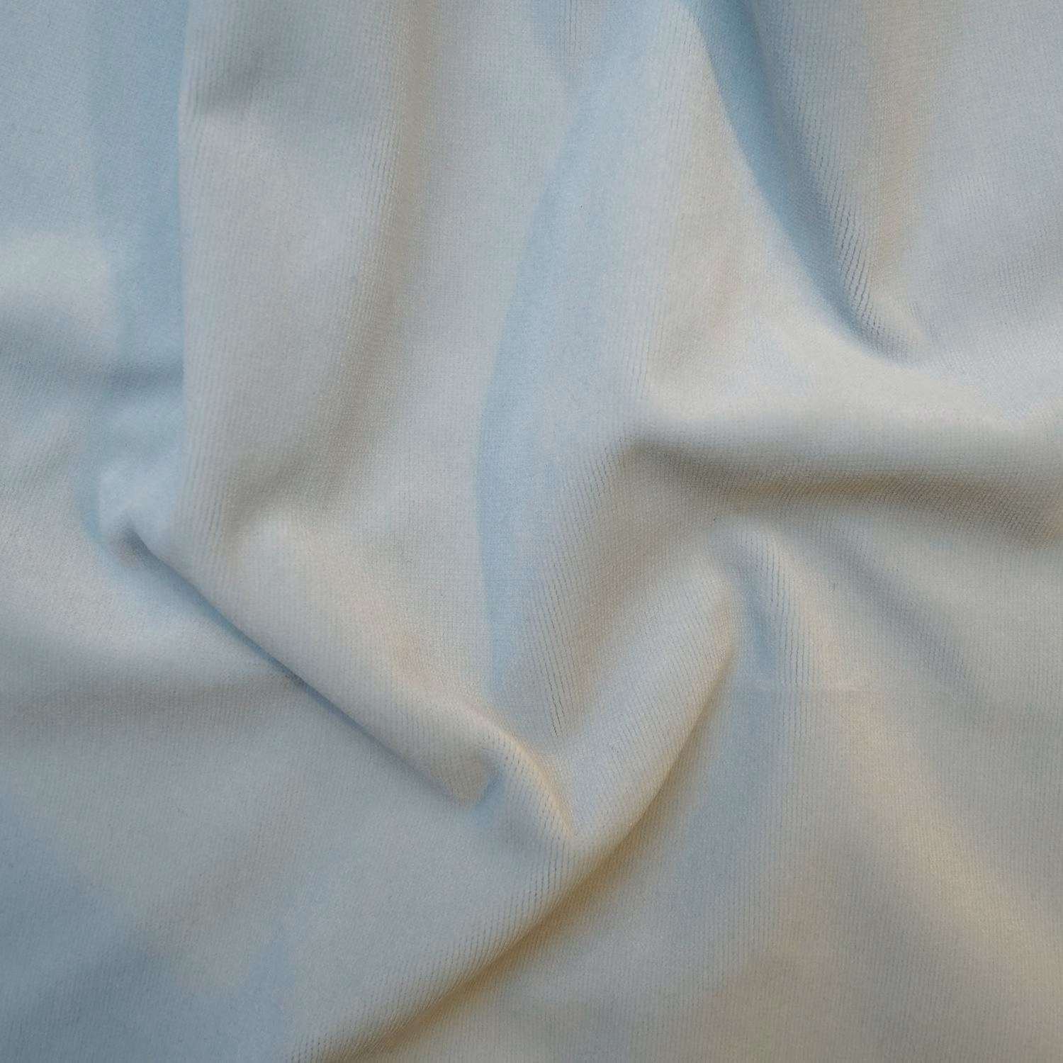 Pale powder-blue ribbed fabric draped into soft folds with creamy highlights