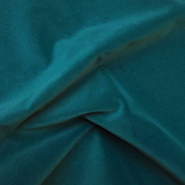 Deep teal fabric with a plush sheen, folded to reveal shifting highlights