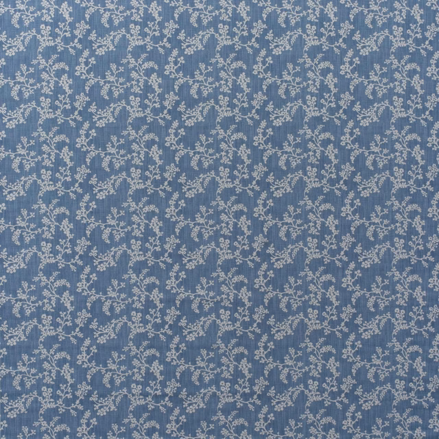 Muted denim-blue cotton with delicate ivory scrolling flowers and leafy vines