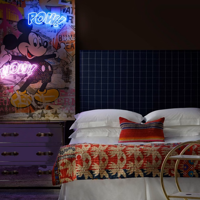 Deep navy, red and cream botanical weave draped across a white bed