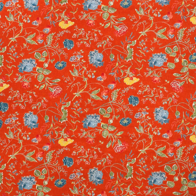 Pumpkin-red floral fabric with blue blooms, green foliage and fine yellow botanical stems