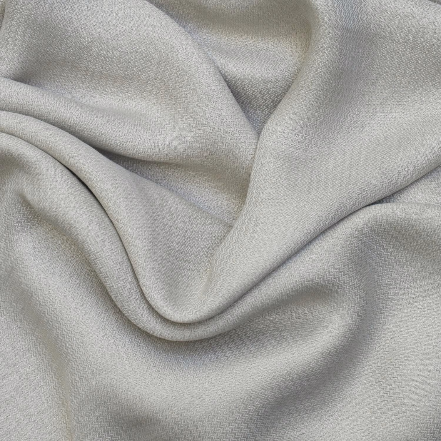 Pale sage-grey fabric draped in folds with a fine miniature chevron weave