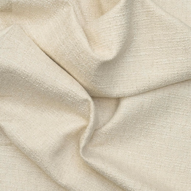 Pale chalk-cream plain textured fabric with fine grain and softly folded drape